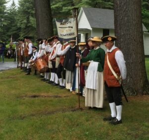A group of people in Colonial garb stand at attention at Mount Hope Cemetery.