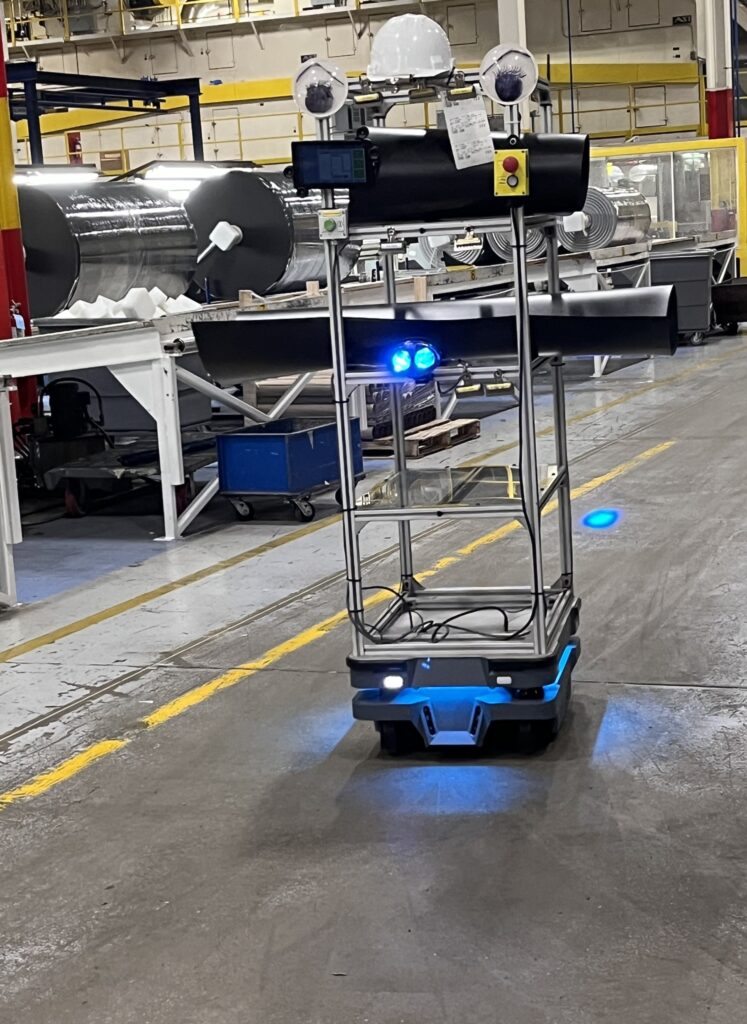 Wally is a cart with wheels and blue lights. He sports a white hard hat and very large googly eyes, complete with eyelashes.