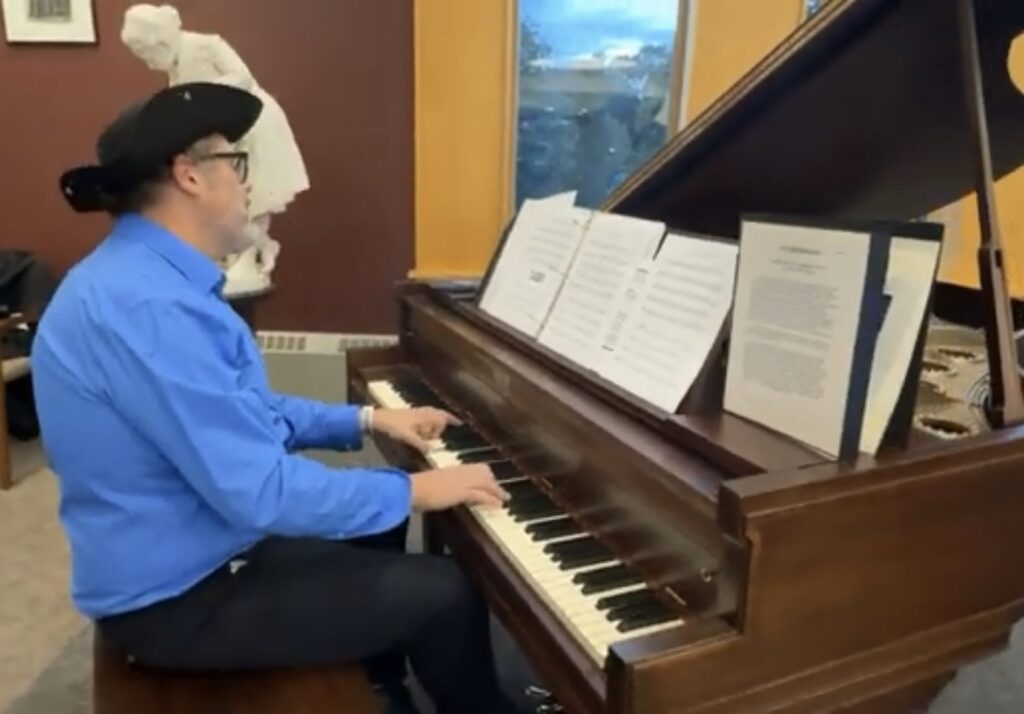 A man wearing a tricorner hat plays the piano.