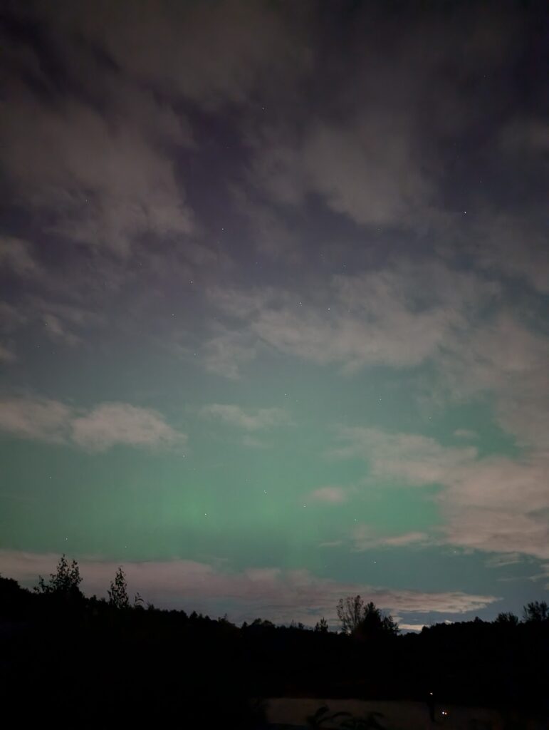 Clouds in a greenish sky. You can see a few stars in the background.