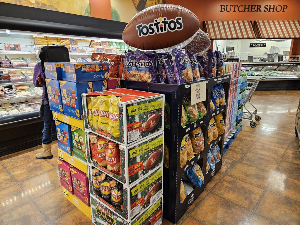 A store display with a Tostitos football, but a number of different brands that fall under the Frito-Lay/PepsiCo brand.
