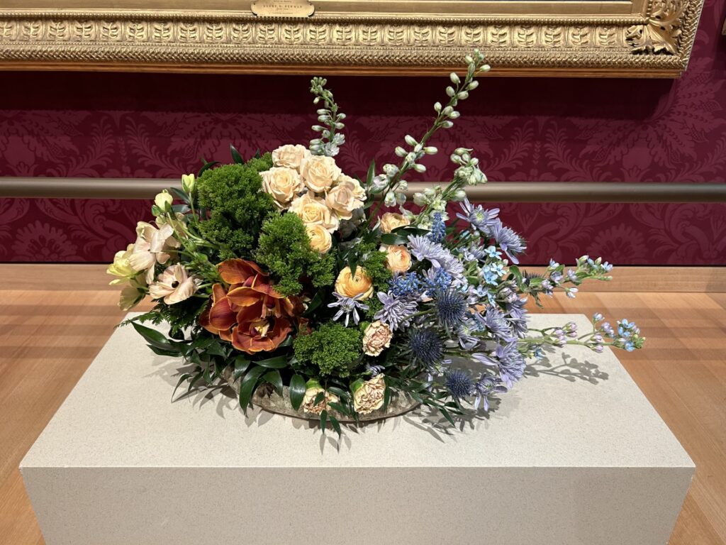 A bowl of off white roses and other flowers that nicely evokes the colors and feeling of the painting.