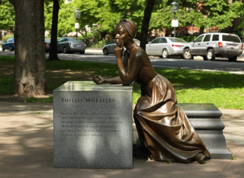 A bronze statue of a young Black woman leans on a granite pedastal. She is wearing a simple 18th C dress and cap, The pedestal contains information about her life, including birth and death dates (ca 1753 - 1784).