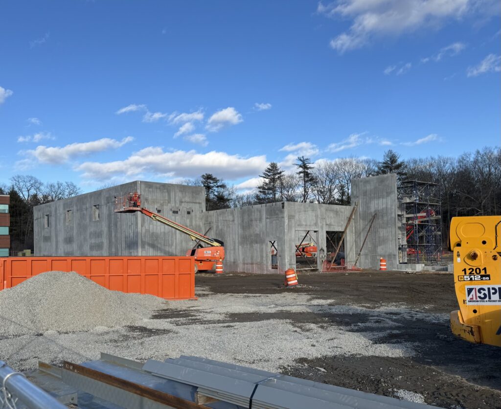 A construction site with slabs of concrete going up on a multi-story structure.