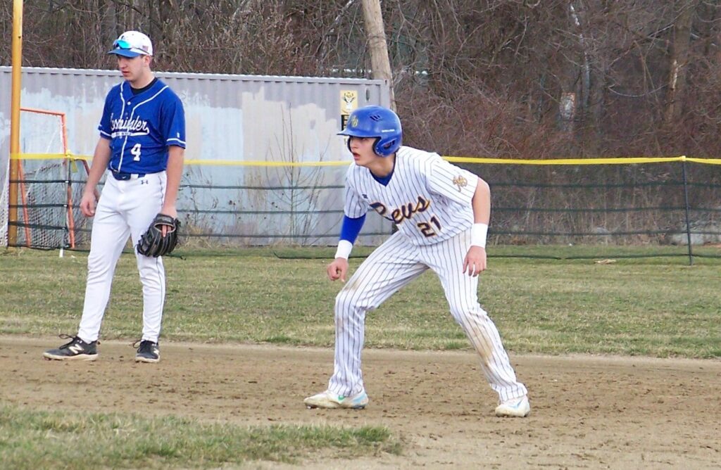 A Revs player is on base, looking intently to see if he can run for the next base.