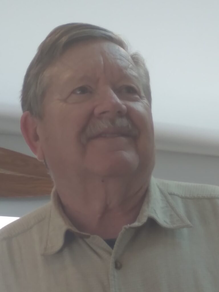 An older man looks off into the distance.