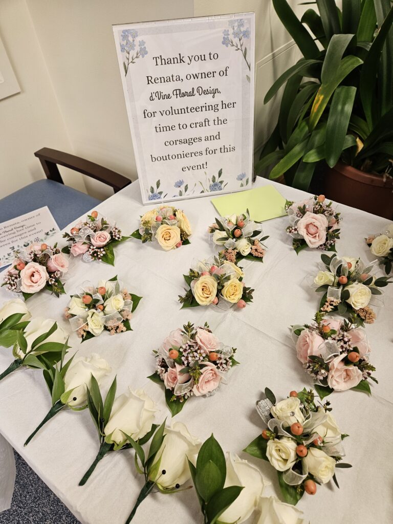 A table with corsages and boutonnieres, with a thank you sign to Renata, the owner of d'Vine Floral Design.