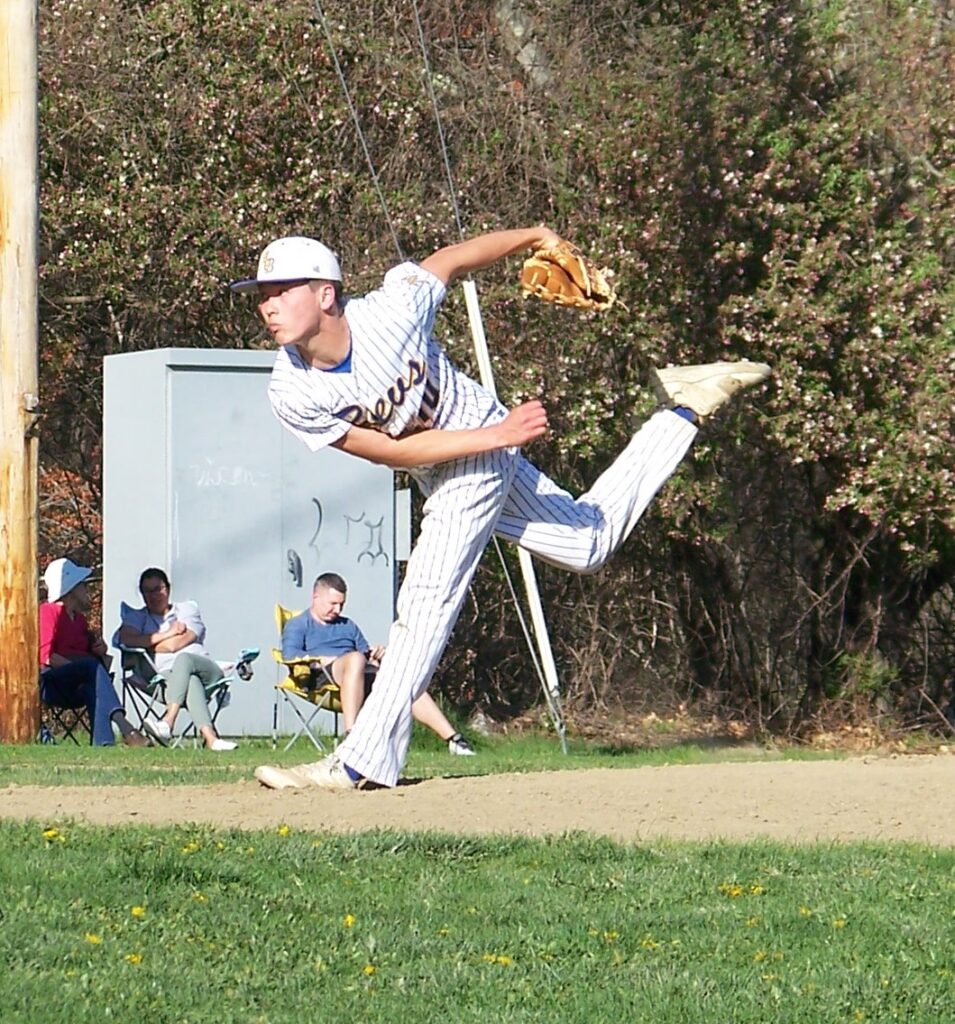 A Revs player is caught mid-pitch. Some parents sit in the background.