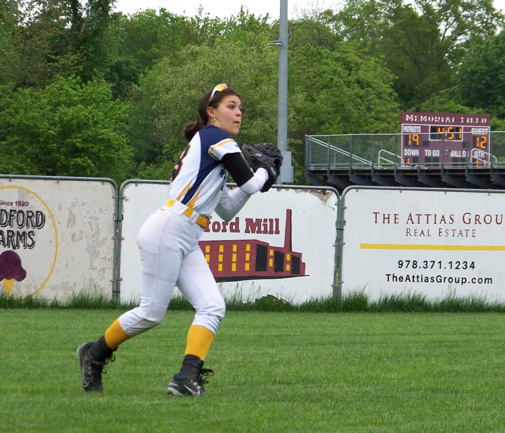 A Revs player twists her body to catch a fly ball.