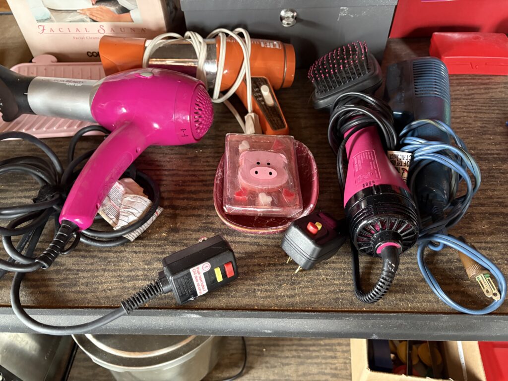 Hair dryers, a hot comb, and other small appliances wait for a new home.