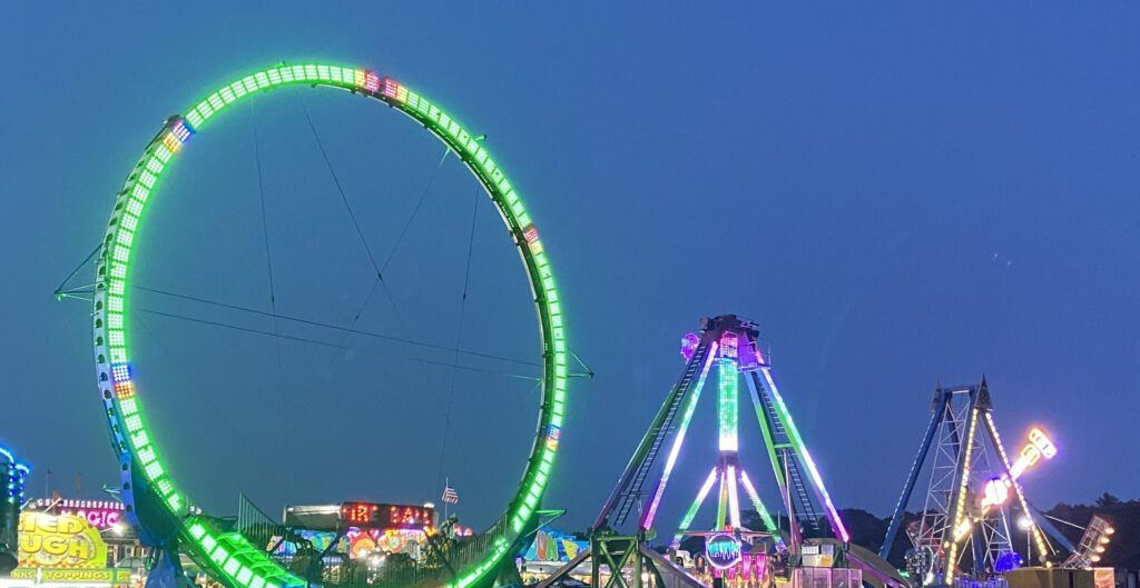 Rides are lit up against the nighttime sky.