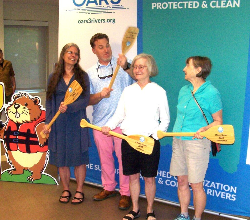 The foour OARS volunteers of the year stand up with their small oars that are given by OARS as awards.
