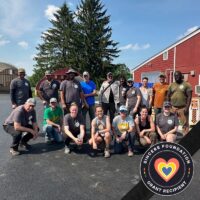 Staff and volunteers from Boston Area Gleaners pose in front of a red barn. The Sincere Foundation Grant Recipient logo is in the bottom right.