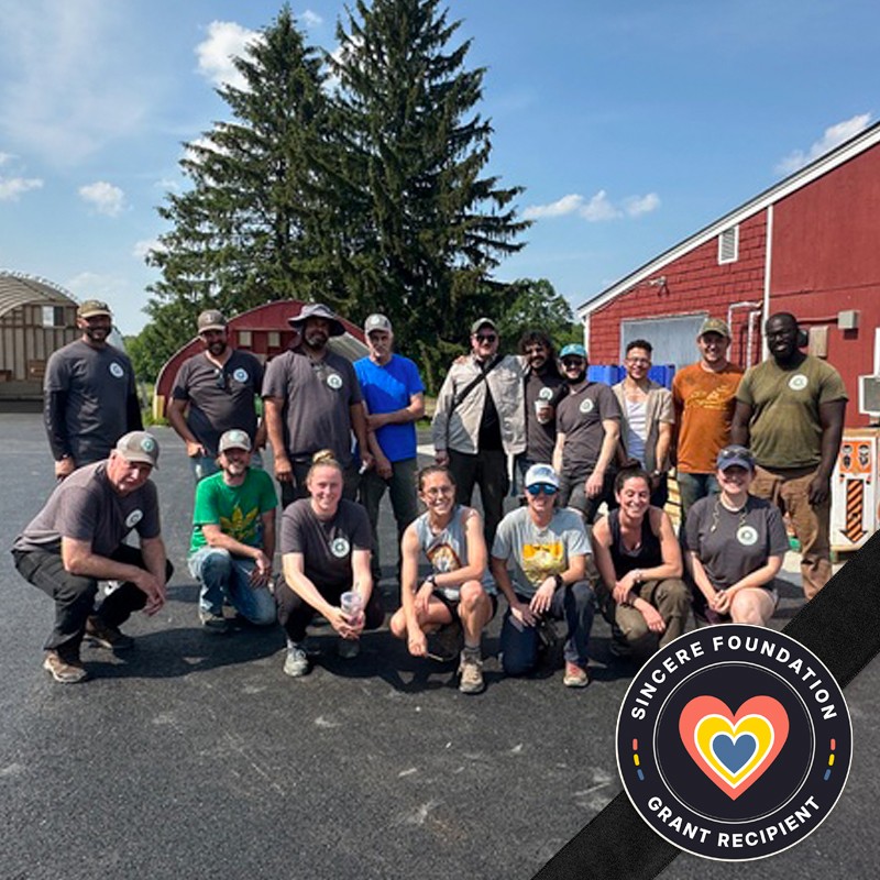 Staff and volunteers from Boston Area Gleaners pose in front of a red barn. The Sincere Foundation Grant Recipient logo is in the bottom right.