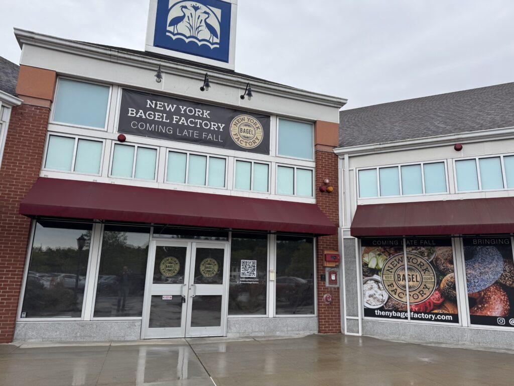An empty storefront with a sign that proclaims "New York Bagel Factory, coming late fall."