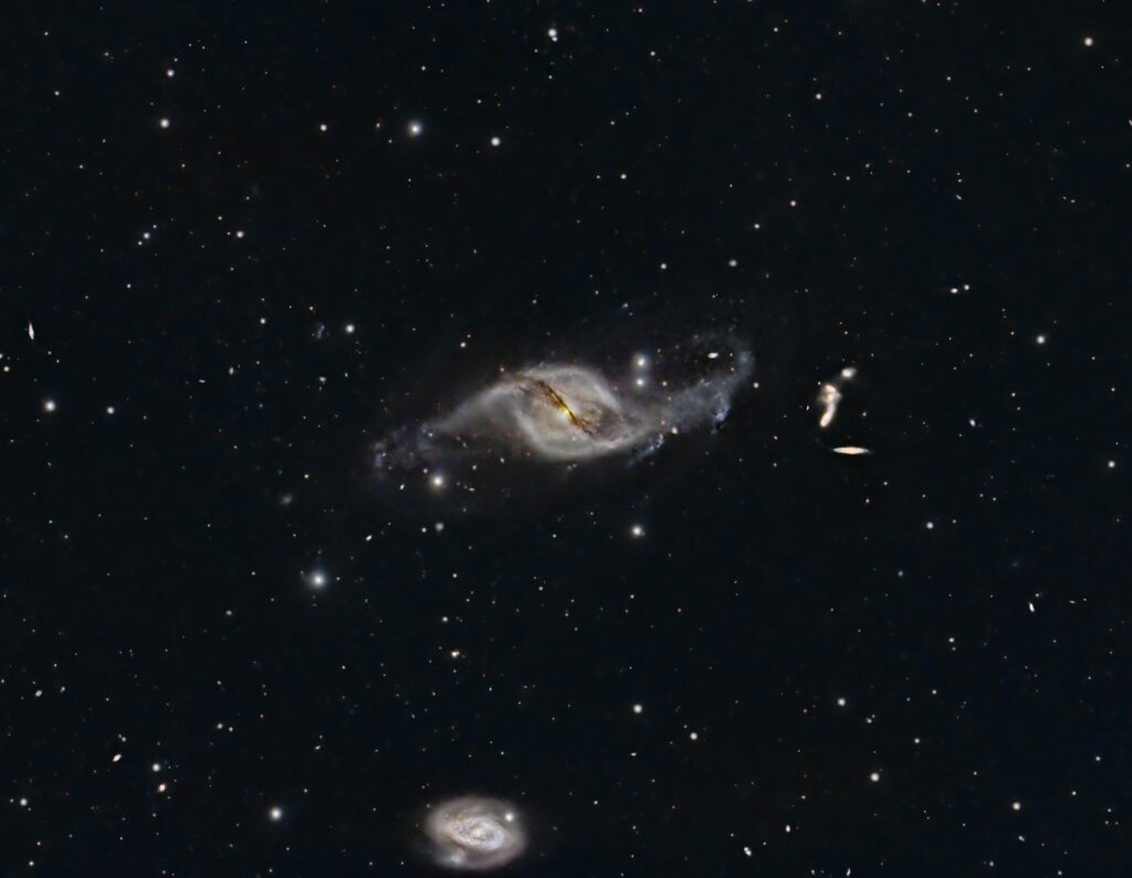 Two hazy white circular or spiral shapes on a black sky full of smaller stars.