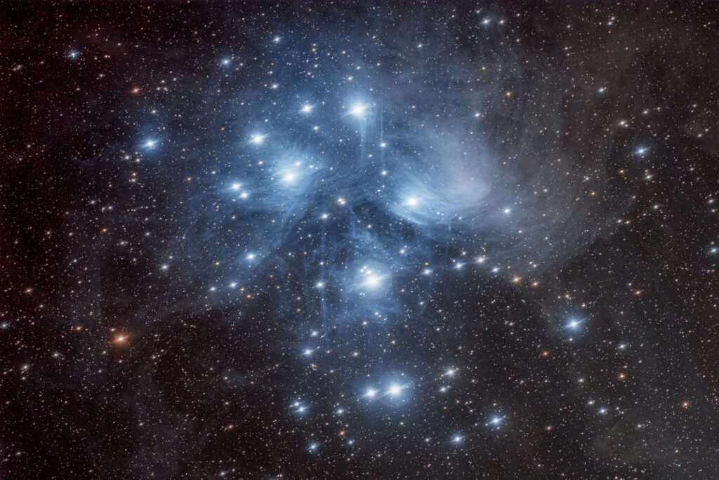 Hazy white circles around ten or twenty large bright stars, with many smaller white and yellow stars filling the rest of the photograph.