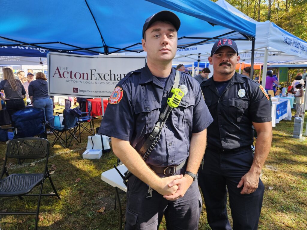Two Acton fire fighters stand in front ot the Acton Exchange booth.
