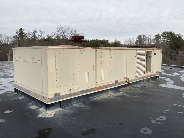 A somewhat rusted small metal building on a rooftop.