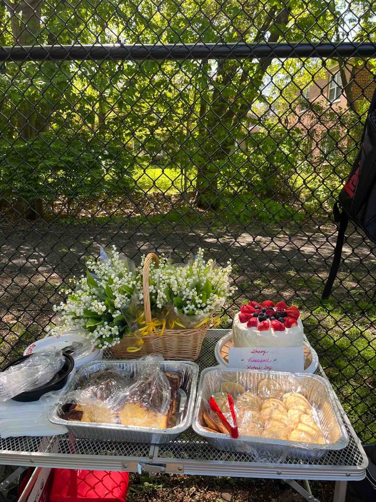A table with tasty looking treeats and bundles of flowers in a basket.