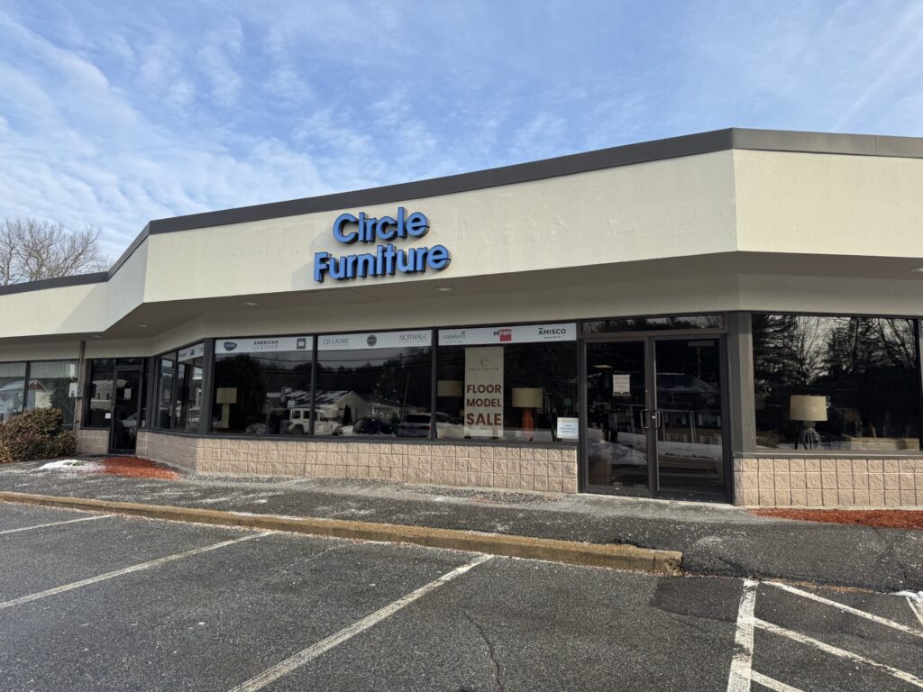 A building with the Circle Furniture logo and some signs on the door.