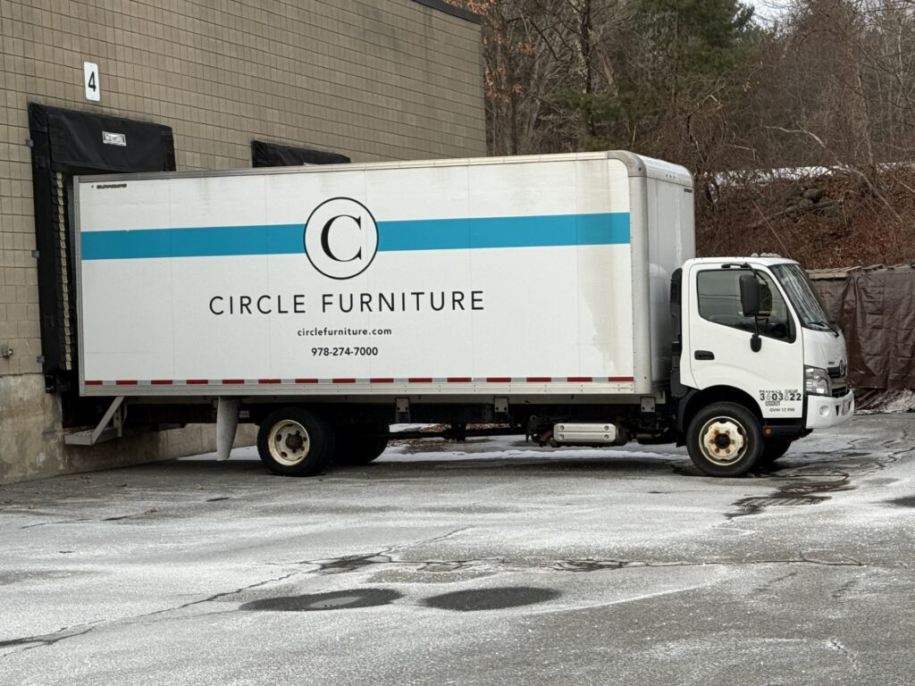 A large white truck sits in front of a loading dock.