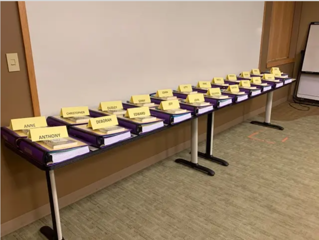 Two tables lined with books and nametags on top of each stack of books.
