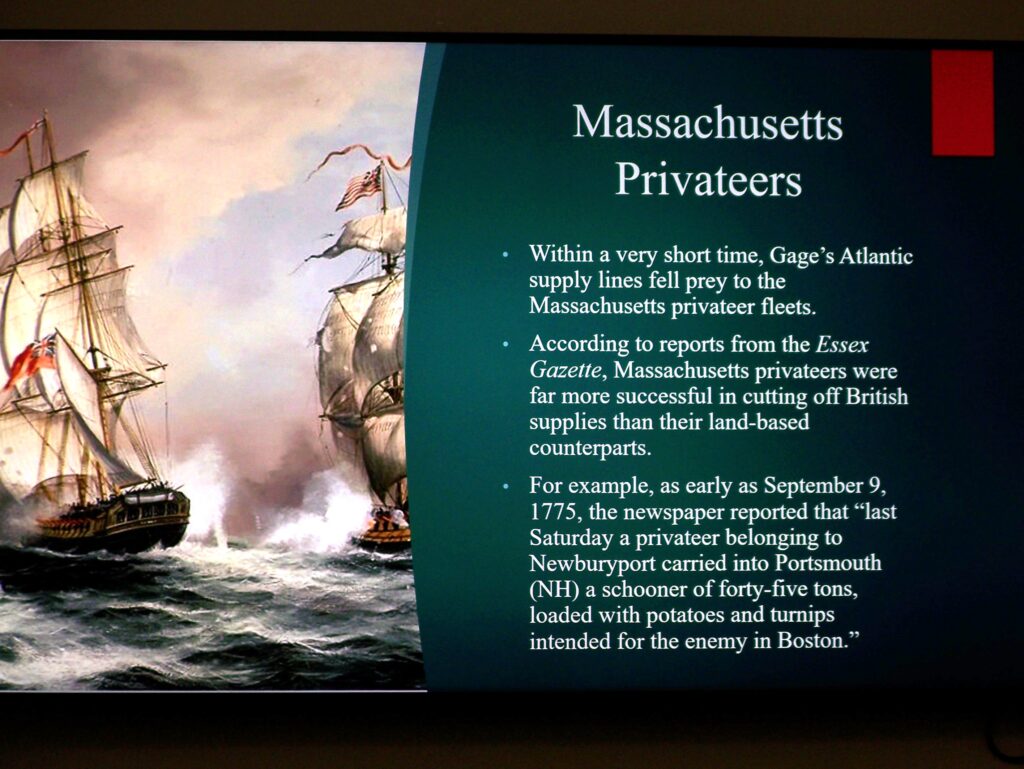 A photo of one of Mr. Cain's slides: On the left, sailing ships at war, on the right, a description of Massachusetts privateers.