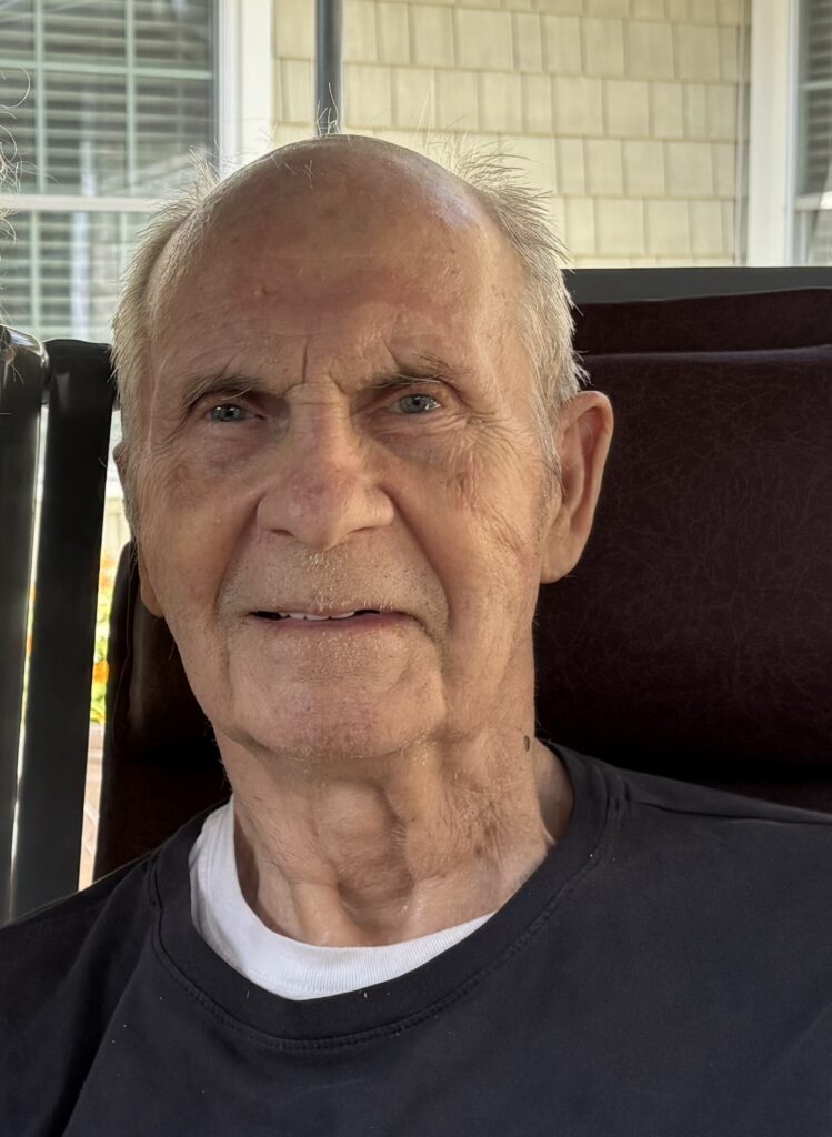 An older man sitting outdoors.