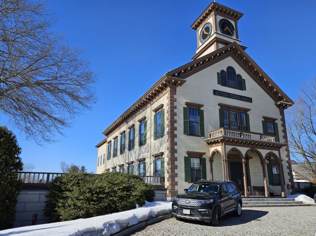 Acton's gingerbready Town Hall, painted cream and brown sparkles in the sunlight.